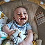 Jose is registered to the contest to win money with this photo: baby, blanket, smiling, happy, infant, child, cushion, baby_seat, indoor, clothing, person, cute, face, hand, wood_floor, soft_texture, comfort, joy, playful, portrait