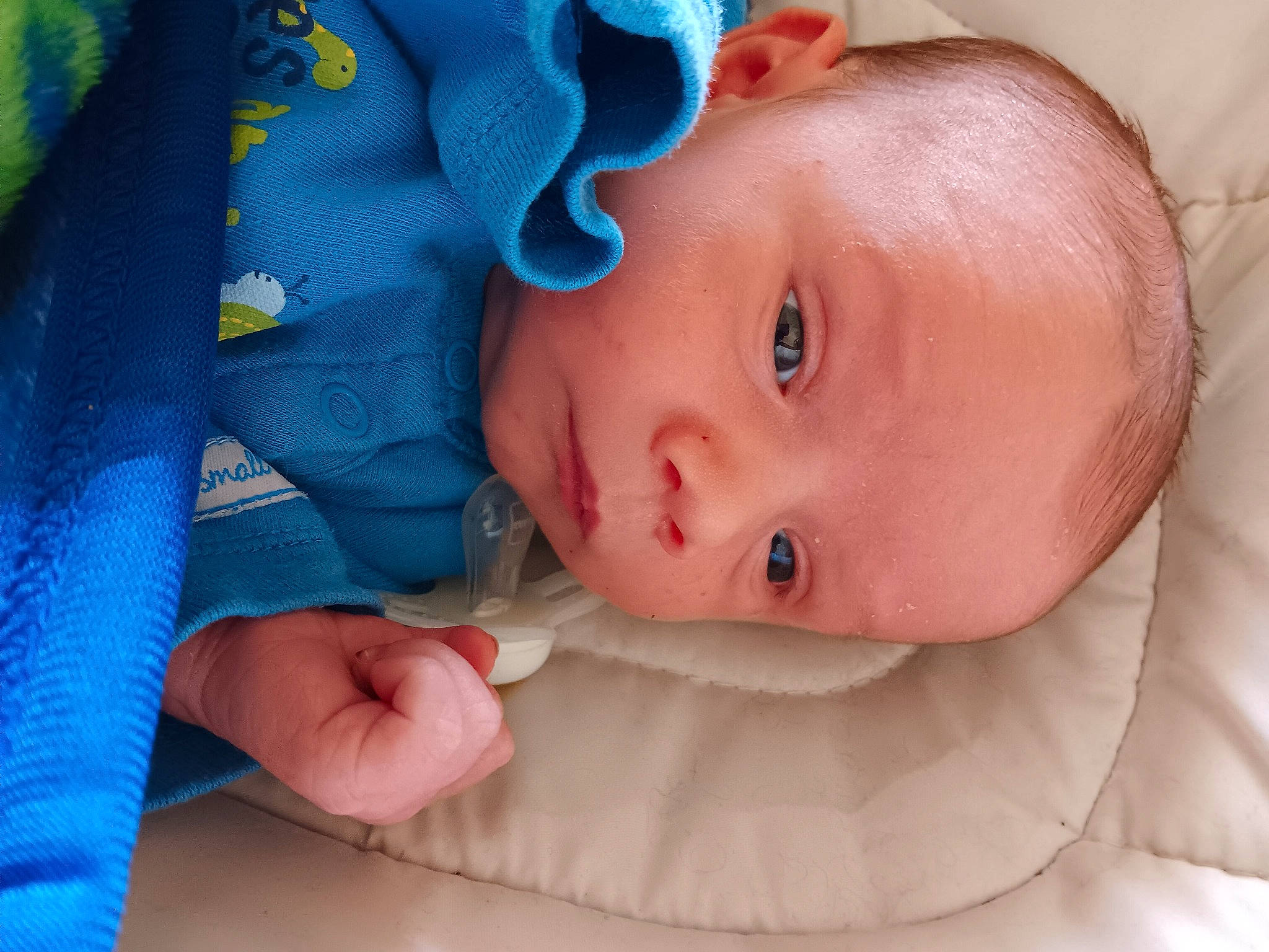 Colt is registered to the contest to win money with this photo: baby, baby_products, baby_toddler_clothing, blue, cheek, child, close_up, comfort, electric_blue, eyelash, iris, linens, lip, nail, pattern, person, portrait_photography, skin, sleeve, textile