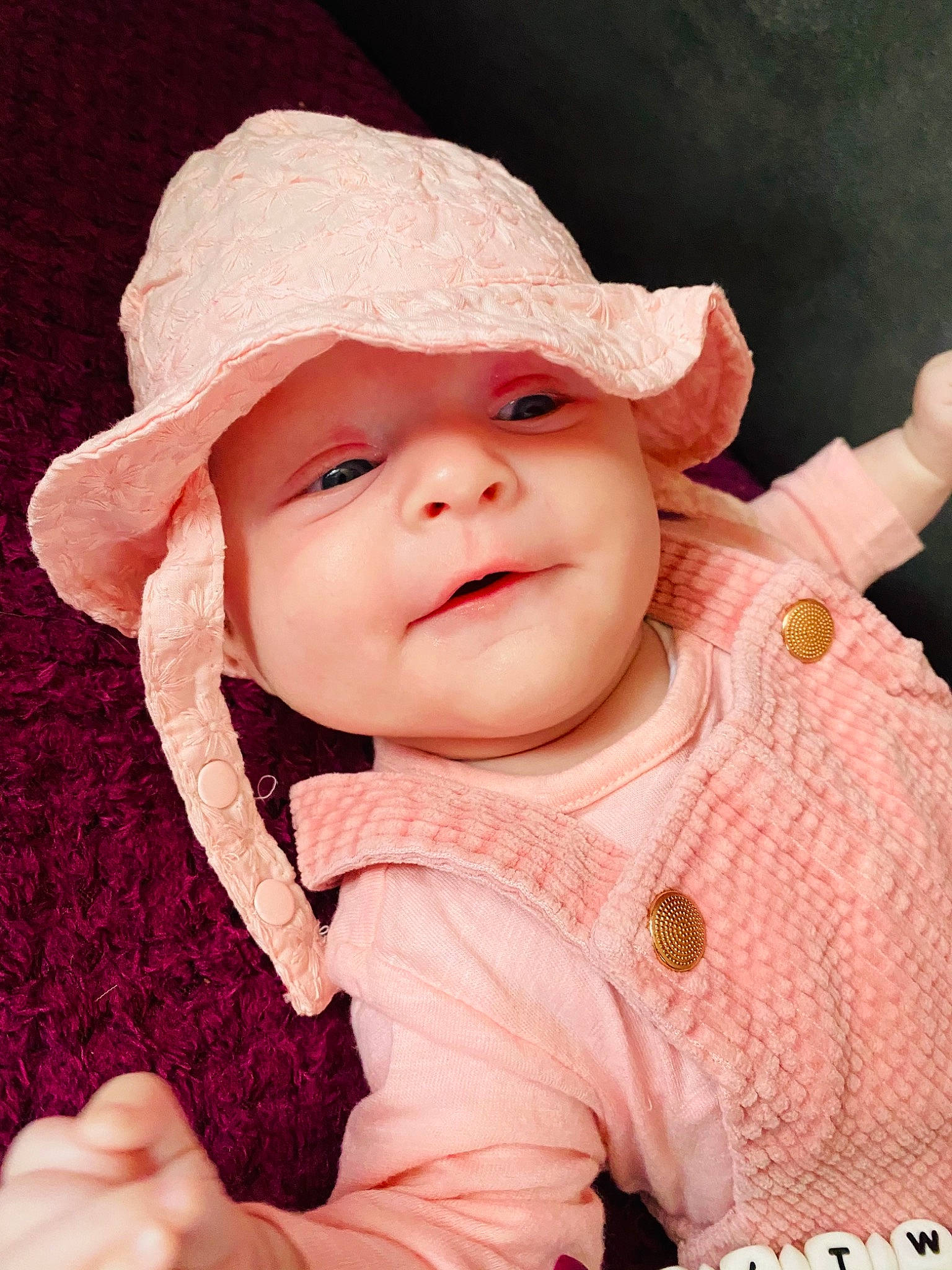 Mïya participe au concours pour gagner de l'argent avec cette photo : baby, baby_toddler_clothing, cap, cheek, chin, face, facial_expression, gesture, happy, hat, headwear, lip, magenta, nose, person, pink, product, skin, sleeve, smile