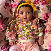Azayla joined the competition — help win amazing prizes! baby, child, clothing, cushion, cute, fabric, floral, headband, indoors, infant, pants, pattern, person, pink, portrait, sitting, smile, sweater, yellow, young