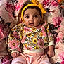 baby, child, clothing, cushion, cute, fabric, floral, headband, indoors, infant, pants, pattern, person, pink, portrait, sitting, smile, sweater, yellow, young