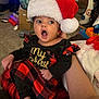 Azayla joined the competition — help win amazing prizes! baby, carpet, celebration, child, christmas, clothing, cute, dress, expression, festive, hand, holding, holiday, indoor, infant, open_mouth, person, plaid, santa_hat, wide_eyes