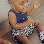 Aaliyah is registered to the contest to win money with this photo: toddler, child, smiling, happy, sitting, leopard_print, shorts, sneakers, hair_bows, indoor, floor, playful, cute, joyful, skin, person, clothing, footwear, hand, portrait