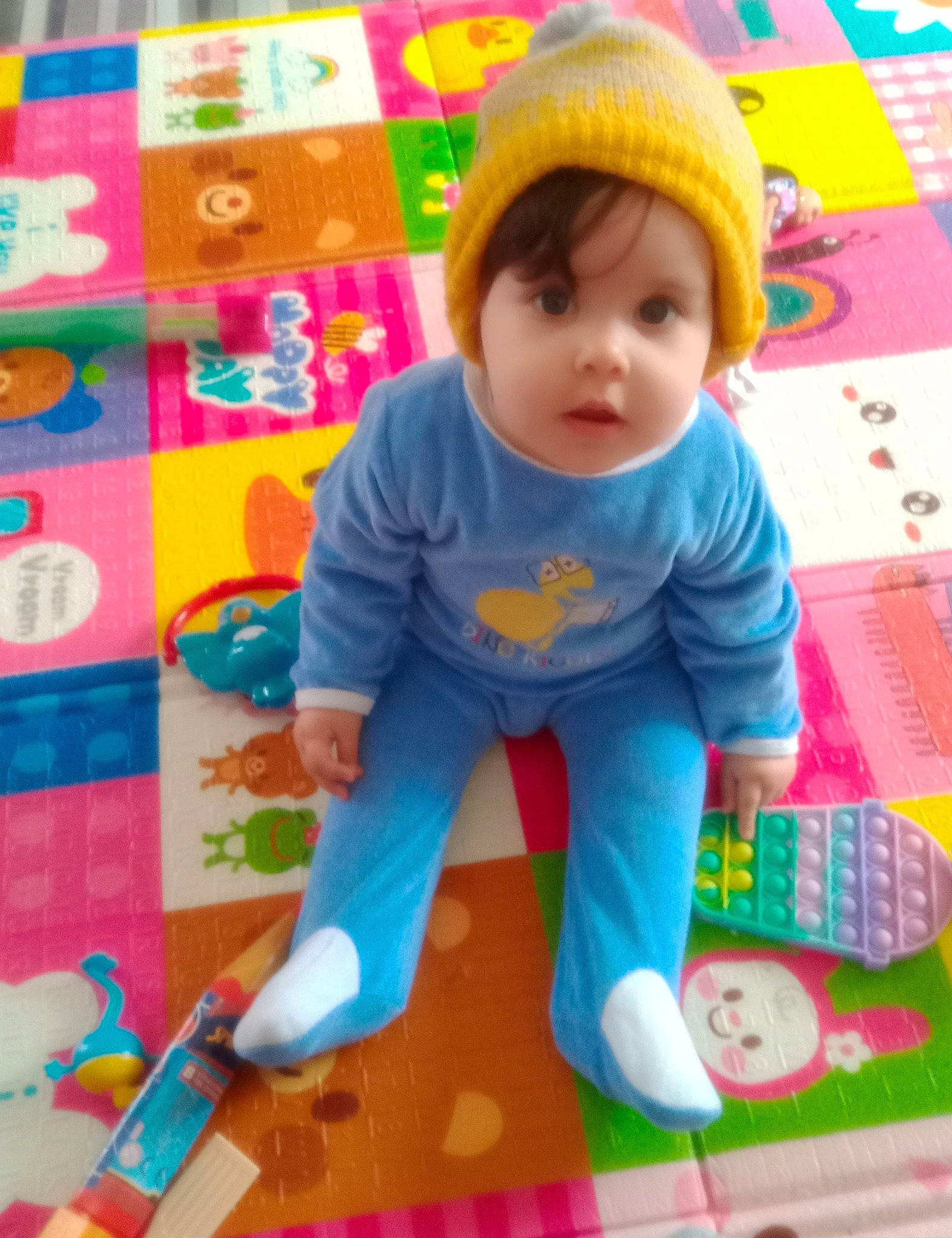 Iris participe au concours pour gagner de l'argent avec cette photo : baby, baby_playing_with_toys, baby_products, baby_toddler_clothing, baby_toys, child, flooring, fun, head, pattern, person, play, playmat, room, sitting, sleeve, smile, t_shirt, toddler, toy