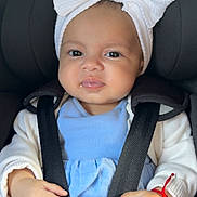 Alessia joined the competition — help win amazing prizes! baby, blue_clothing, bow, car_seat, child, closeup, cute, face, hands, headband, indoors, infant, pacifier, portrait, red_bracelet, safety, seatbelt, smile, straps, white_cardigan