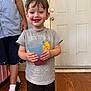 adult, child, clothing, cup, door, drink, feet, floor, happy, indoor, legs, messy, person, shoes, shorts, smiling, socks, toddler, tshirt, wood