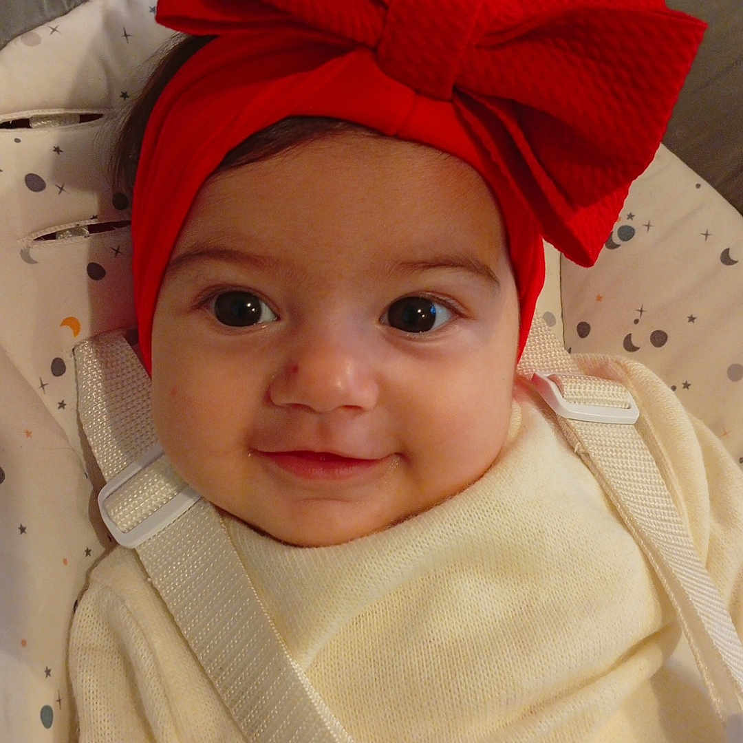 Marie Carmen a rejoint le concours — aidez-le/la à gagner de superbes lots ! baby, baby_seat, child, closeup, clothing, cute, eyes, face, happy, headband, indoor, infant, moons, pattern, portrait, red_bow, seat_belt, smile, stars, sweater