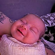 Naylani is registered to the contest to win money with this photo: baby, sleeping, smile, blanket, tattoo, arm, cat, resting, cozy, indoor, portrait, child, peaceful, cute, infant, person, soft, comfort, animal, background