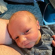 Mccoy joined the competition — help win amazing prizes! baby, newborn, infant, face, eyes, cheeks, onesie, clothing, pillow, blanket, bed, portrait, close_up, skin, ear, hand, arm, parent_leg, sleepy, cozy