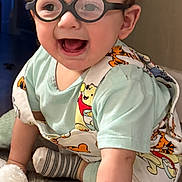 Caesar-Tadeo joined the competition — help win amazing prizes! baby, child, glasses, crawling, toy, plush_toy, indoor, floor, happy, smiling, colorful_clothing, overalls, hand, head, face, light, person, young_child, cute, playful