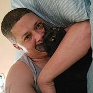 Presley Moses is registered to the contest to win money with this photo: man, person, cat, black_cat, pet, animal, cuddling, hugging, portrait, face, eyes, indoor, bed, pillow, blanket, striped_fabric, cozy, tattoo, short_hair, selfie