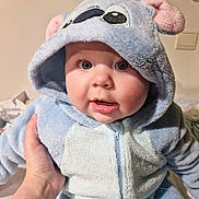Lya participe au concours pour gagner de l'argent avec cette photo : baby, blue_clothing, child, closeup, cute, expression, eyes, face, hand, hooded_onesie, indoor, infant, person, plush, portrait, soft_texture, star_decorations, wall, warm_clothing, young_child