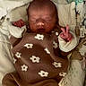 baby, newborn, sleeping, infant, brown_clothing, flower_pattern, blanket, animal_print, cute, peaceful, soft, cozy, child, portrait, indoors, resting, small_hands, face, head, lying_down
