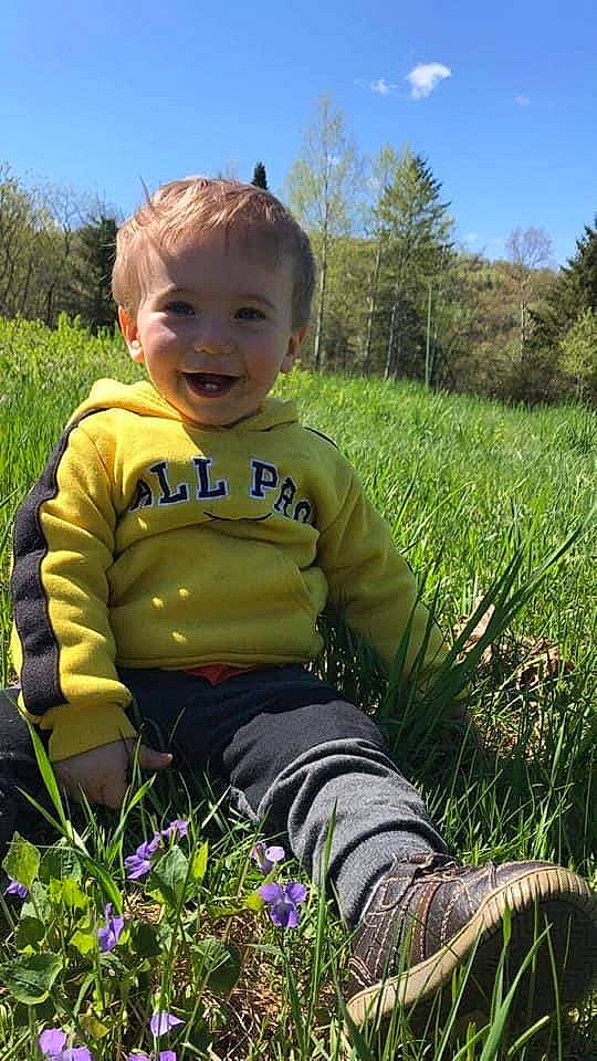 Allan is registered to the contest to win money with this photo: child, fawn, grass, grass_family, grassland, happy, joy, meadow, outerwear, people_in_nature, person, plant, play, portrait, prairie, sitting, smile, spring, toddler, wildflower