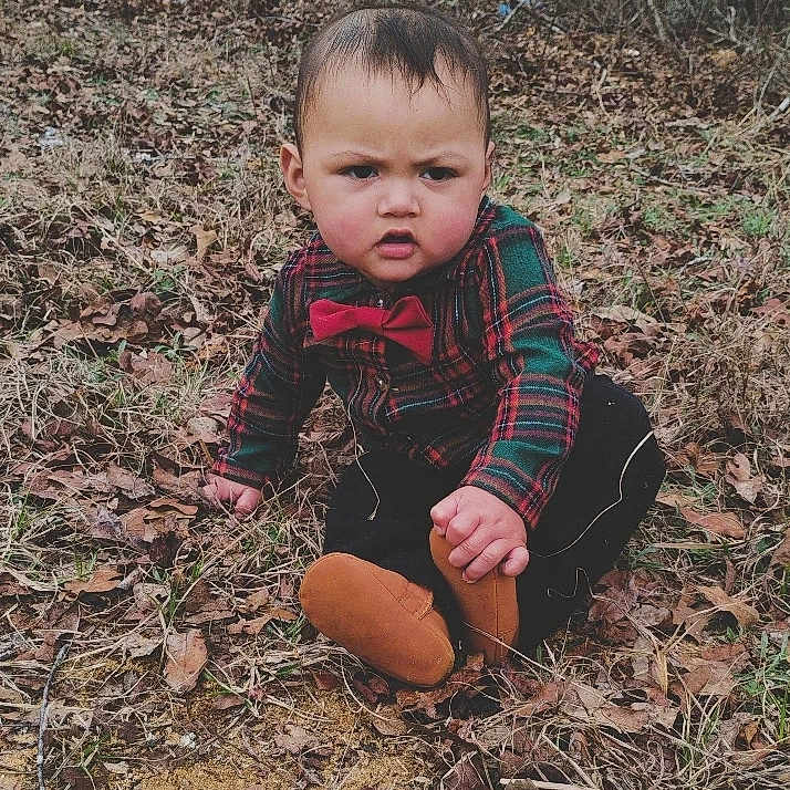 Jhael Elias is registered to the contest to win money with this photo: accessories, americanfootball, americanfootballball, baby, ball, clothing, face, football, formalwear, head, pants, person, photography, plant, portrait, sitting, soil, sport, tie, vegetation