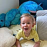 toddler, child, yellow_shirt, smiling, indoor, play_mat, stuffed_animal, blue_toy, pillow, happy, crawling, face, person, cute, home, soft_toy, childhood, young_child, casual, fun