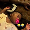 adult_arm, baby, blanket, casual, child, controller, cute, emoji, funny, hand, indoors, infant, pacifier, patterned_fabric, pink, relaxed, resting, sleeping, sofa, video_game