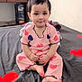 Minha is registered to the contest to win money with this photo: toddler, child, smiling, pajamas, heart_pattern, bed, blanket, red_hearts, black_blanket, indoor, furniture, tv, drawer, person, cute, young_child, sitting, barefoot, cozy, portrait