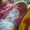 Adeline is registered to the contest to win money with this photo: newborn, baby, infant, sleeping, face, portrait, blanket, swaddled, hat, clothing, cozy, indoors, bed, yellow_blanket, patterned_fabric, peaceful, resting, closeup, family, photography