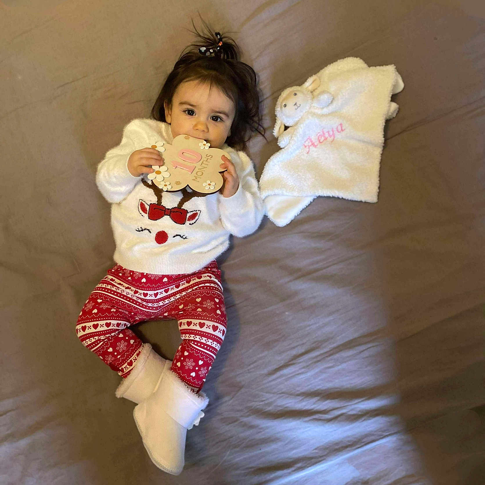 Aélya a rejoint le concours — aidez-le/la à gagner de superbes lots ! baby, bed, blanket, boots, child, clothing, cute, girl, holiday, indoors, infant, leggings, lying_down, milestone_card, person, plush, reindeer, smiling, sweater, toy