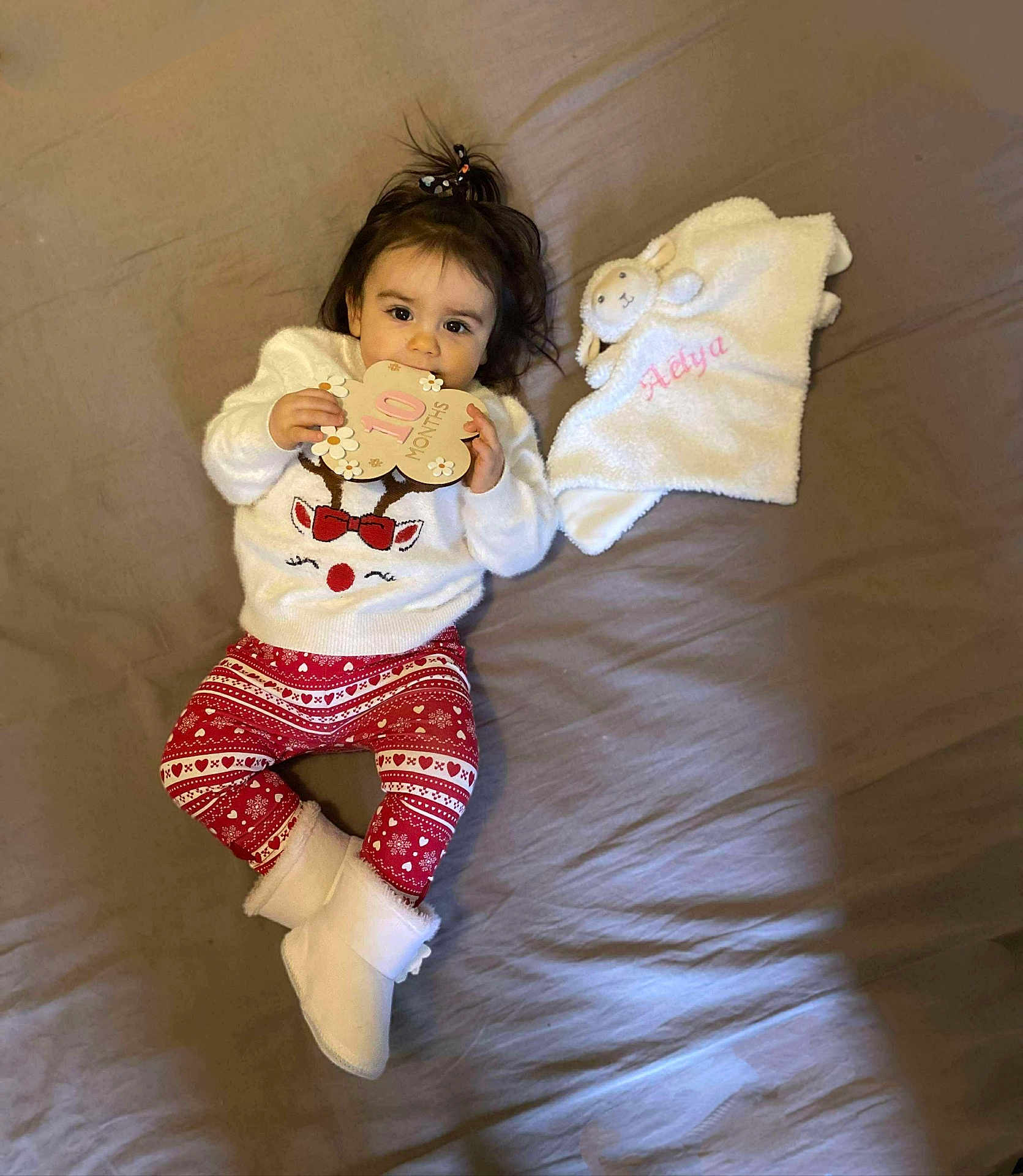 Aélya a rejoint le concours — aidez-le/la à gagner de superbes lots ! baby, infant, child, girl, clothing, sweater, leggings, boots, bed, blanket, plush, milestone_card, reindeer, toy, cute, smiling, indoors, person, lying_down, holiday
