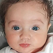 Lyham a rejoint le concours — aidez-le/la à gagner de superbes lots ! baby, infant, closeup, blue_eyes, curly_hair, face, cute, child, portrait, white_clothing, skin, expression, small_lips, young, person, head, indoors, soft_light, innocent, adorable
