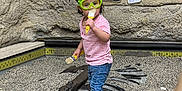 Leiliany joined the competition — help win amazing prizes! toddler, child, goggles, pink_shirt, jeans, sneakers, excavation, dig_site, fossils, brushes, museum, indoor, education, play, curious, standing, rocks, signage, hands, person