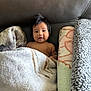 Albert joined the competition — help win amazing prizes! baby, child, blanket, couch, leather, soft, cozy, indoor, portrait, infant, face, smile, dark_hair, expression, wrapped, comfort, warm, cute, young, sitting
