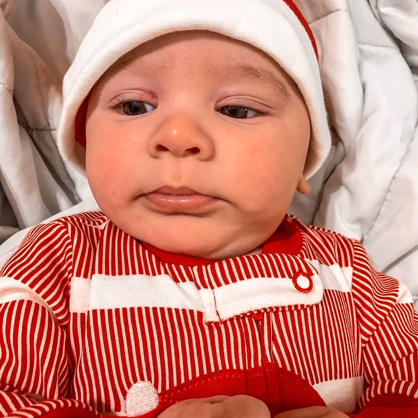 Fabian is registered to the contest to win money with this photo: baby, baby_toddler_clothing, cap, cheek, chin, eye, eyebrow, eyelash, face, facial_expression, head, headwear, human_body, lip, mouth, nose, organ, person, skin, sleeve