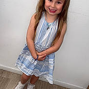 Jade participe au concours pour gagner de l'argent avec cette photo : child, girl, smiling, dress, striped_dress, bandana, headband, standing, white_wall, wooden_floor, sneakers, white_shoes, long_hair, bracelet, necklace, happy, casual_clothing, indoor, portrait, cute