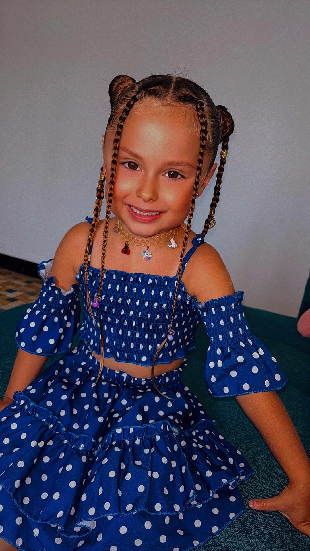 Jade a rejoint le concours — aidez-le/la à gagner de superbes lots ! child, girl, smiling, braids, hair_buns, blue_dress, polka_dot, sitting, couch, indoor, necklace, cute, happy, fashion, portrait, young, person, casual, colorful, accessories