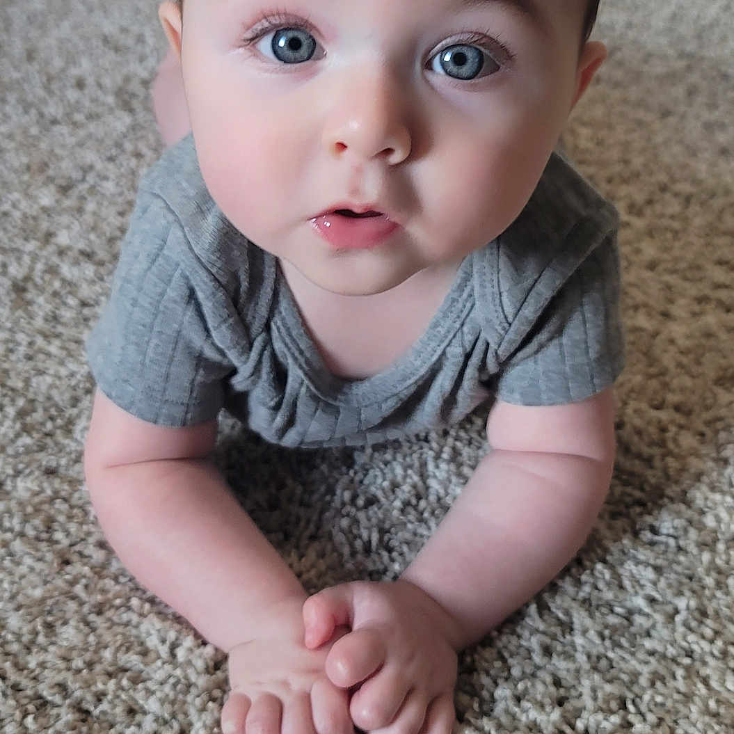 Chase is registered to the contest to win money with this photo: baby, bodypart, clothing, couch, crawling, face, finger, hand, happy, head, homedecor, newborn, pants, person, photography, portrait, sitting, smile, t_shirt, toe