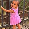 toddler, child, pink_dress, outdoor, bridge, metal_gate, wooden_floor, curious, looking_back, sandals, rusty, nature, greenery, person, portrait, young_child, summer, daylight, standing, baby