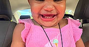 Melody is registered to the contest to win money with this photo: accessory, baby, car_interior, child, closeup, clothing, cute, face, hair_tie, happy, indoors, joyful, person, pink_dress, portrait, seat, sitting, smiling, toddler, young_child