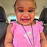 Melody is registered to the contest to win money with this photo: accessory, baby, car_interior, child, closeup, clothing, cute, face, hair_tie, happy, indoors, joyful, person, pink_dress, portrait, seat, sitting, smiling, toddler, young_child