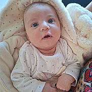 Elisa-Lina participe au concours pour gagner de l'argent avec cette photo : baby, infant, blanket, hood, cozy, soft_toy, hand, face, expression, clothing, patterned_fabric, curious, wide_eyes, indoor, cute, child, portrait, warm, newborn, fuzzy