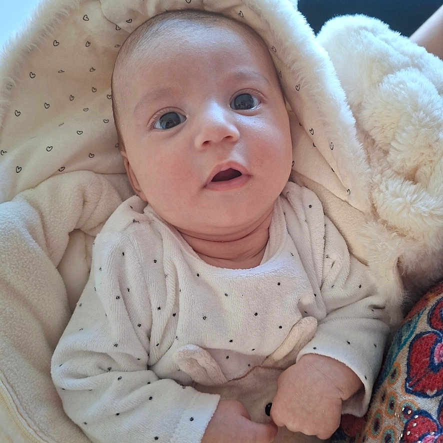 Elisa-Lina participe au concours pour gagner de l'argent avec cette photo : baby, blanket, child, clothing, cozy, curious, cute, expression, face, fuzzy, hand, hood, indoor, infant, newborn, patterned_fabric, portrait, soft_toy, warm, wide_eyes