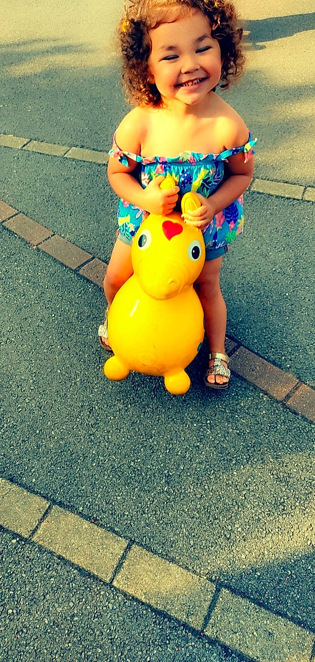 Hanneya participe au concours pour gagner de l'argent avec cette photo : abdomen, asphalt, child, costume, electric_blue, flooring, fun, grass, happy, human_leg, joint, joy, leisure, person, road_surface, sandal, sitting, snapshot, thigh, toy
