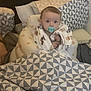 Casey joined the competition — help win amazing prizes! baby, pacifier, blanket, cushion, pillow, infant, seat, child, indoor, cozy, patterned_blanket, patterned_pillow, wrapped, cute, young_child, soft_lighting, home, comfort, portrait, curious