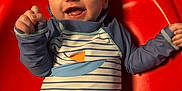 Casey joined the competition — help win amazing prizes! baby, child, smiling, happy, red_chair, striped_clothing, patterned_clothing, indoor, infant, cute, joyful, portrait, person, sitting, playful, colorful, raised_arms, young_child, face, clothing