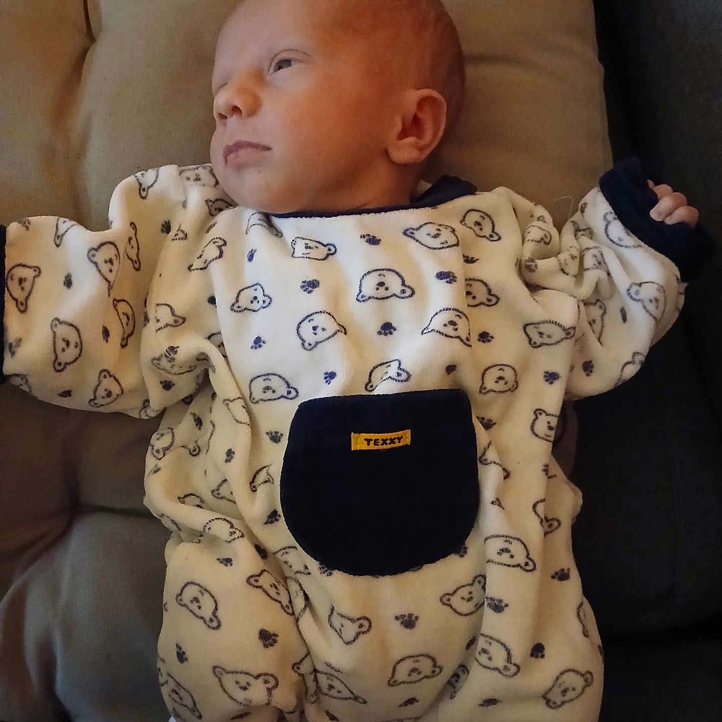 Adrían a rejoint le concours — aidez-le/la à gagner de superbes lots ! baby, bear_pattern, child, clothing, couch, cushion, cute, face, head, indoors, infant, newborn, onesie, person, portrait, relaxed, resting, sleepwear, small_hand, soft
