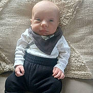 Adrían participe au concours pour gagner de l'argent avec cette photo : baby, bib, blanket, clothing, couch, cozy, cute, face, footwear, hand, home, indoor, infant, person, portrait, relaxed, sitting, soft, texture, young_child