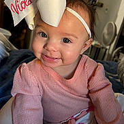 Viola joined the competition — help win amazing prizes! baby, child, smile, headband, bow, pink_sweater, indoor, portrait, cute, face, eyes, happy, infant, person, apparel, sitting, young_child, human, closeup, soft_lighting