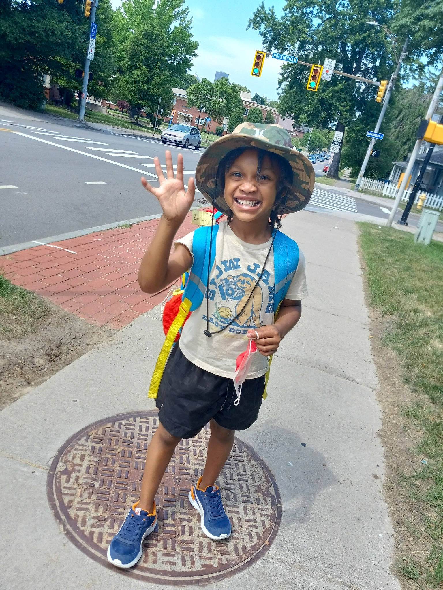 Zion is registered to the contest to win money with this photo: asphalt, child, cool, electric_blue, fun, happy, hat, headgear, headwear, infrastructure, joy, leisure, person, plant, recreation, road, shorts, sky, smile, sneakers