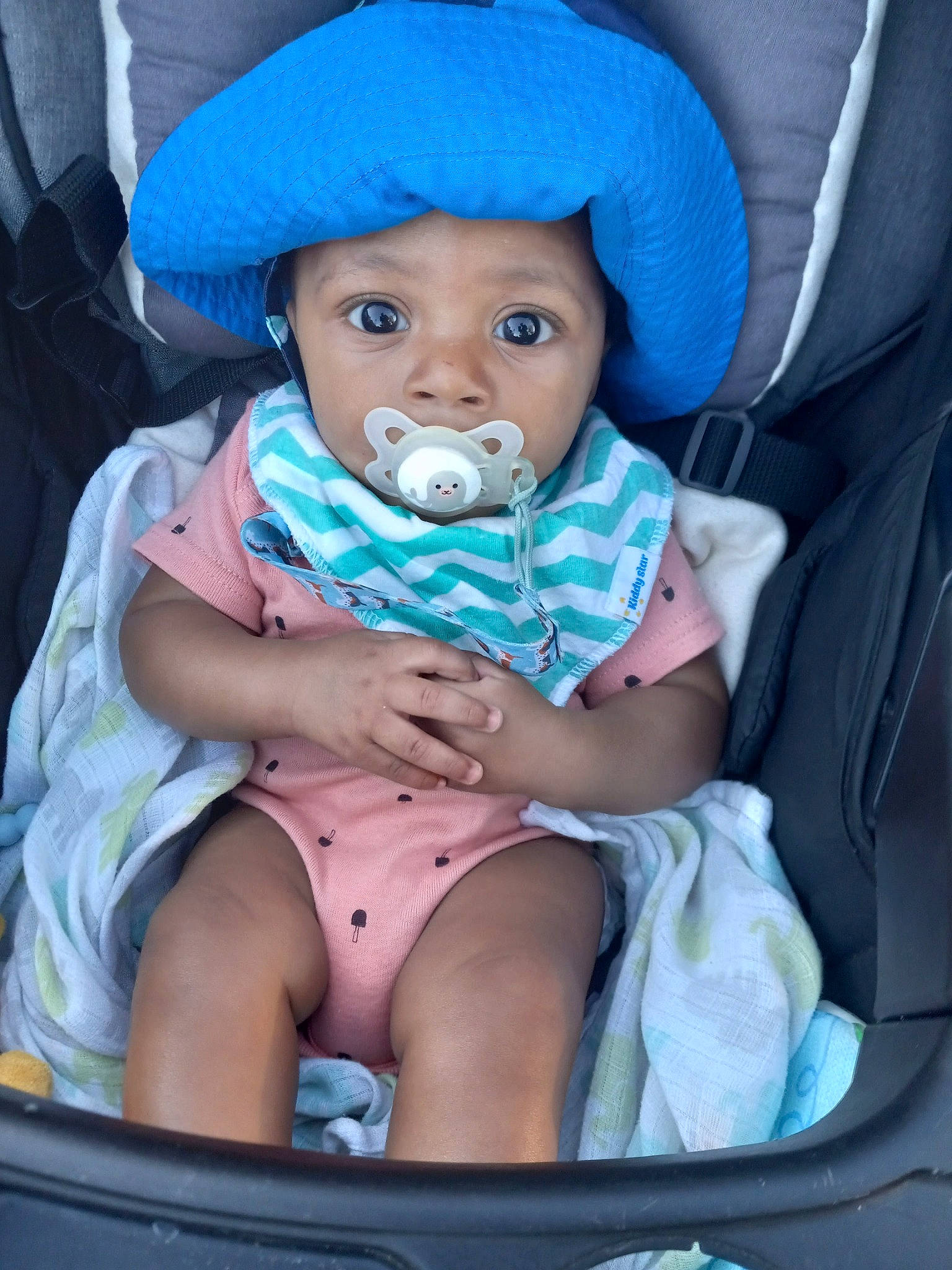 Cornelius is registered to the contest to win money with this photo: baby, baby_carriage, baby_toddler_clothing, blue, cap, car_seat, cheek, child, comfort, electric_blue, eye, face, hat, head, headwear, mouth, people, person, pink, product