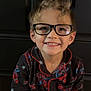 child, glasses, smile, pajamas, spiderman, hair, happy, face, person, clothing, portrait, indoors, childhood, cute, black_background, eyewear, young, fashion, funny_hair, casual