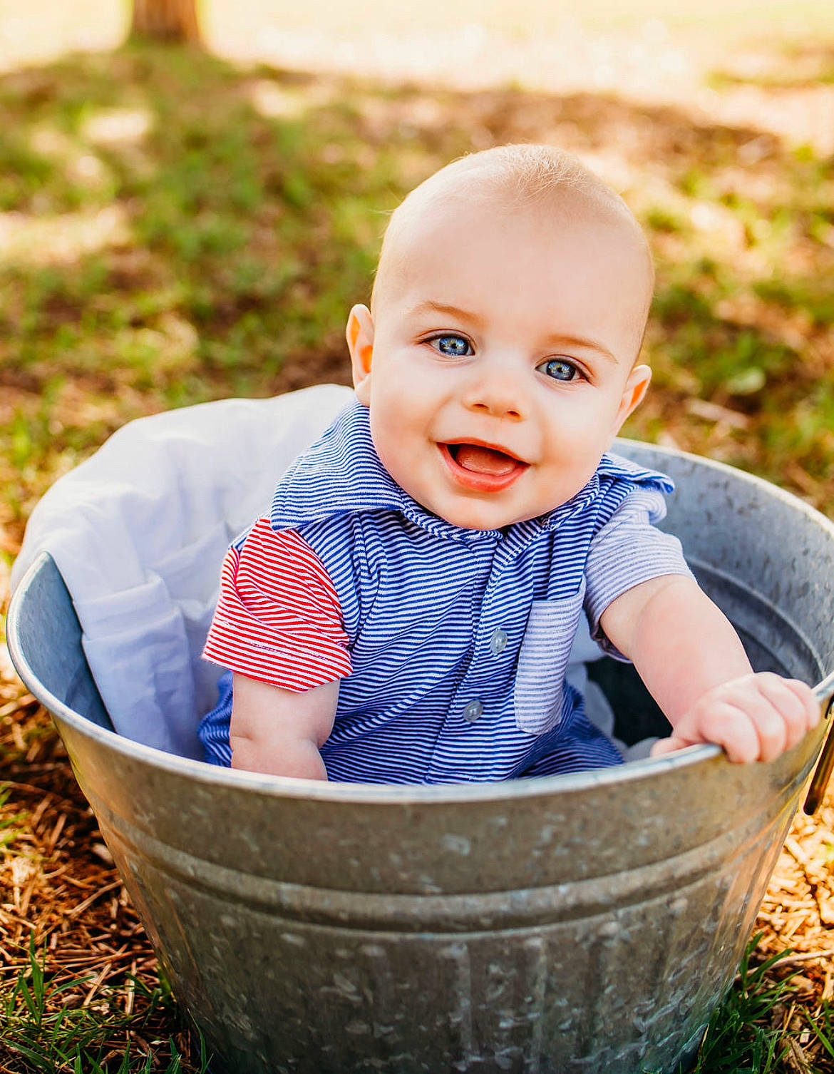 Noah is registered to the contest to win money with this photo: arm, baby, baby_toddler_clothing, cheek, eye, face, facial_expression, grass, hairstyle, hand, happy, head, joy, people_in_nature, person, plant, product, skin, smile, toddler