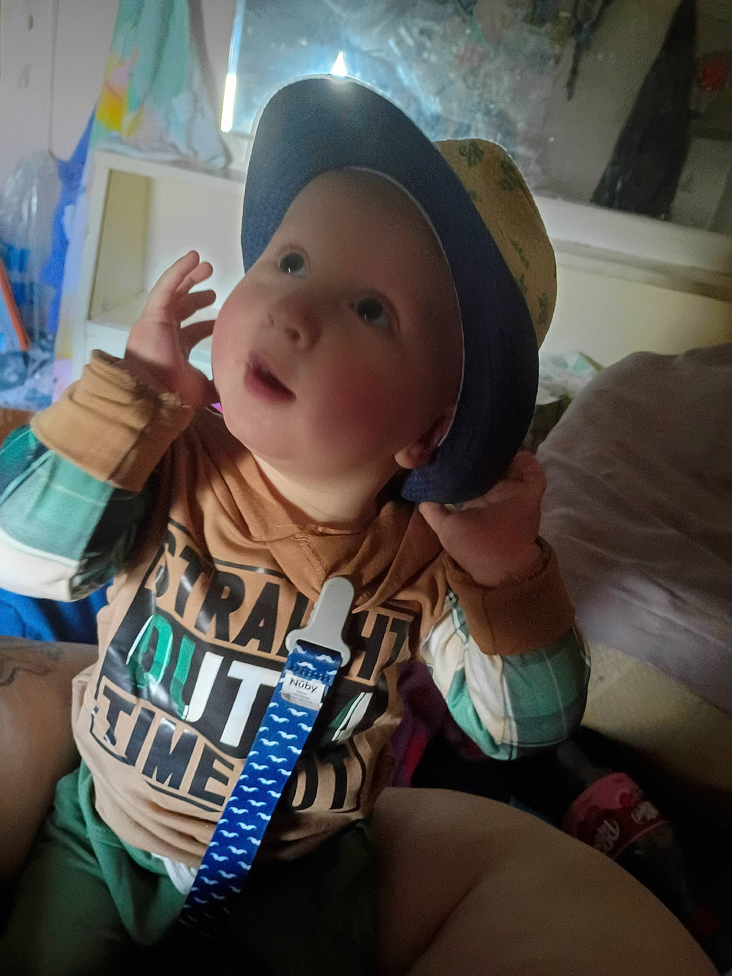 Waylon Chaos is registered to the contest to win money with this photo: baby, casual, child, clothing, colorful, cozy, curious, expression, face, hat, indoor, pacifier_clip, person, playful, portrait, seated, shirt, soft_lighting, toddler, young_child