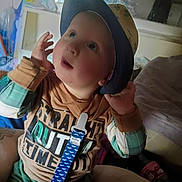 Waylon Chaos joined the competition — help win amazing prizes! baby, casual, child, clothing, colorful, cozy, curious, expression, face, hat, indoor, pacifier_clip, person, playful, portrait, seated, shirt, soft_lighting, toddler, young_child