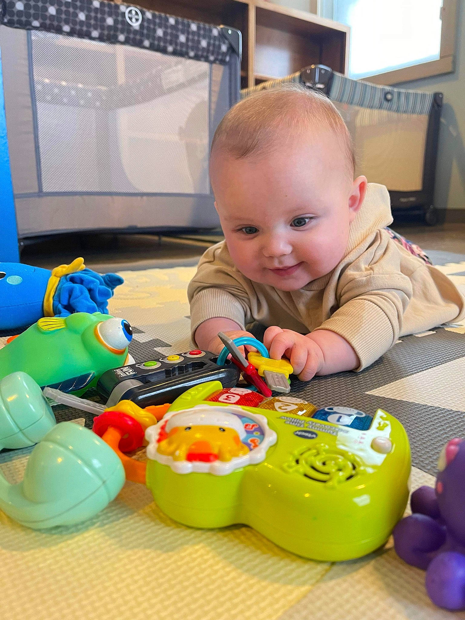 Emily joined the competition — help win amazing prizes! baby, baby_playing_with_toys, baby_products, baby_toddler_clothing, baby_toys, blue, child, flooring, fun, person, plastic, play, product, room, sitting, smile, toddler, toy, toy_vehicle, wood